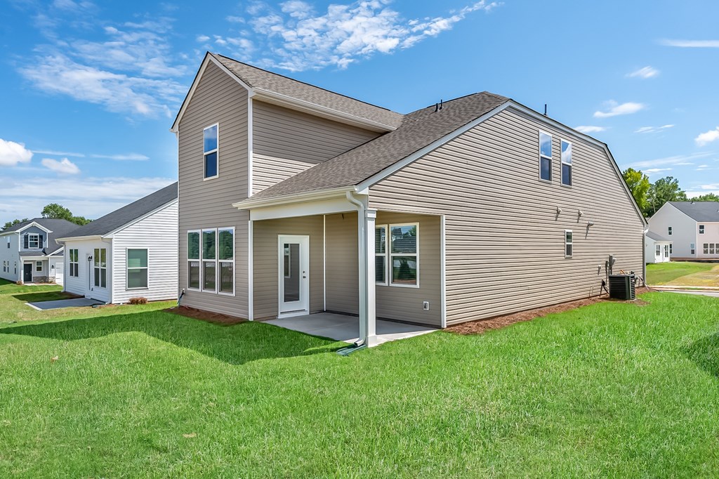 the back of a house with a lawn and a yard next to it