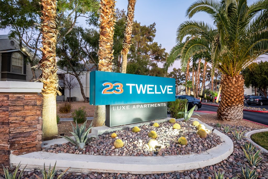 a sign for the 23 tyvee live apartments in front of palm trees