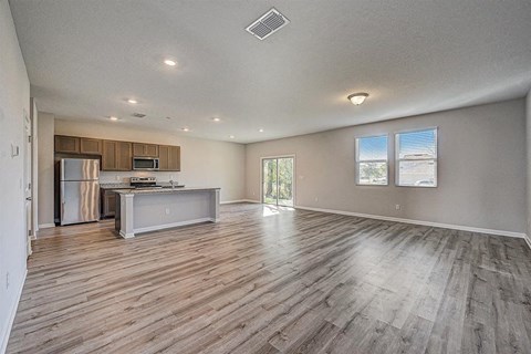 Open-concept living space with kitchen, island, and sliding glass doors.