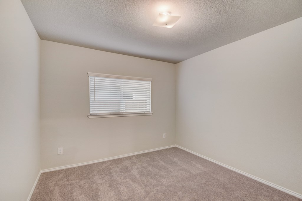 an empty room with carpet and a window