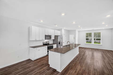 A modern kitchen with white cabinets and a central island.