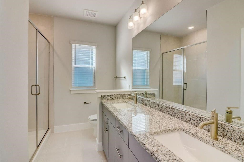 a bathroom with two sinks and a shower