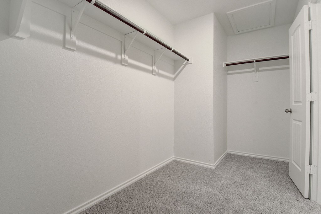 an empty room with white walls and a closet with a white door