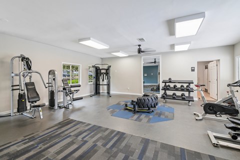 A gym with a variety of equipment including weights and cardio machines.