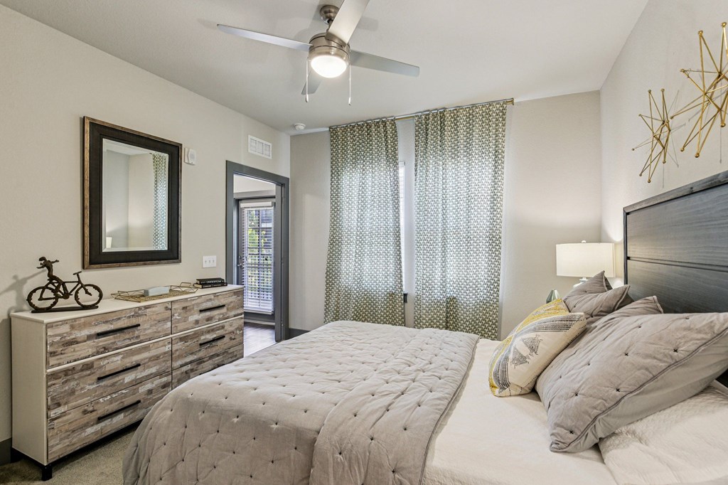Cozy bedroom with natural light, ceiling fan, and neutral decor at Lotus at Starkey Ranch in Odessa, Florida.