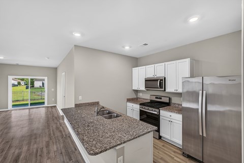 A kitchen with a granite countertop and stainless steel appliances.
