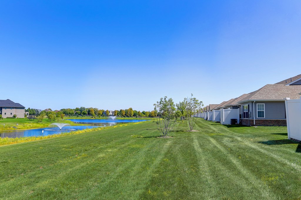a yard with a house next to a body of water