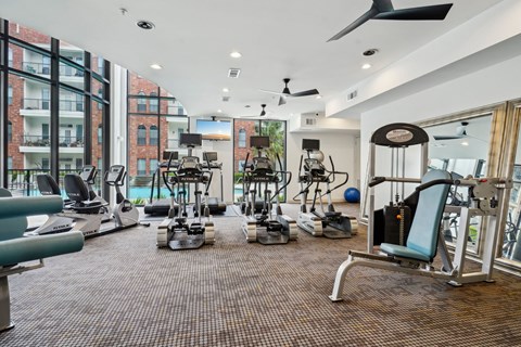A gym with a variety of equipment including treadmills, weights, and exercise machines.