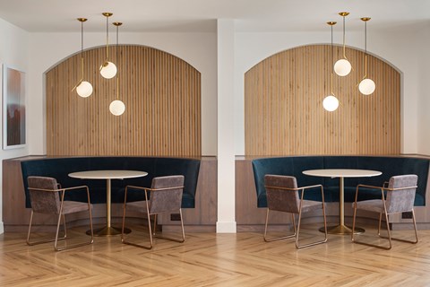 A dining room with a wooden wall and a table with chairs.