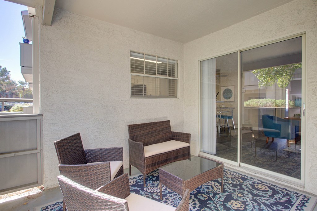 a patio with chairs and a glass table