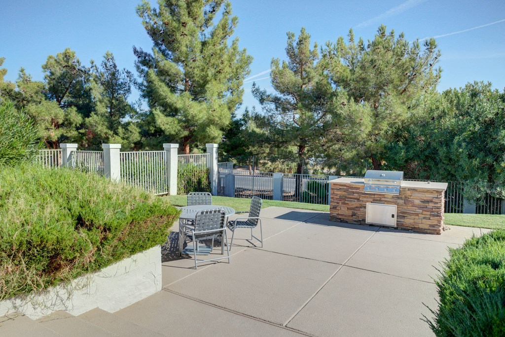 a patio with a table and chairs and a fire pit