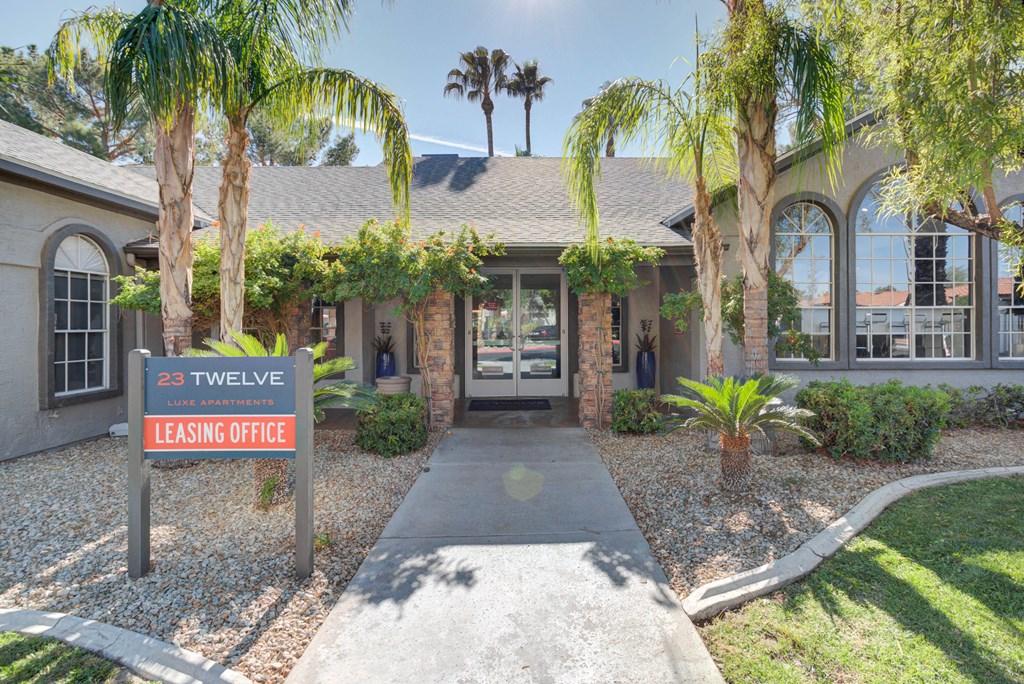 a home with a leasing office and palm trees