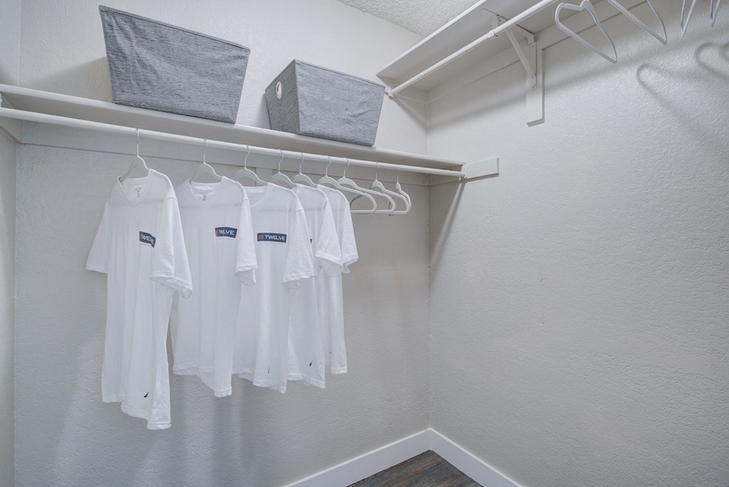 a dressing room with white clothes hanging on a rack on the wall