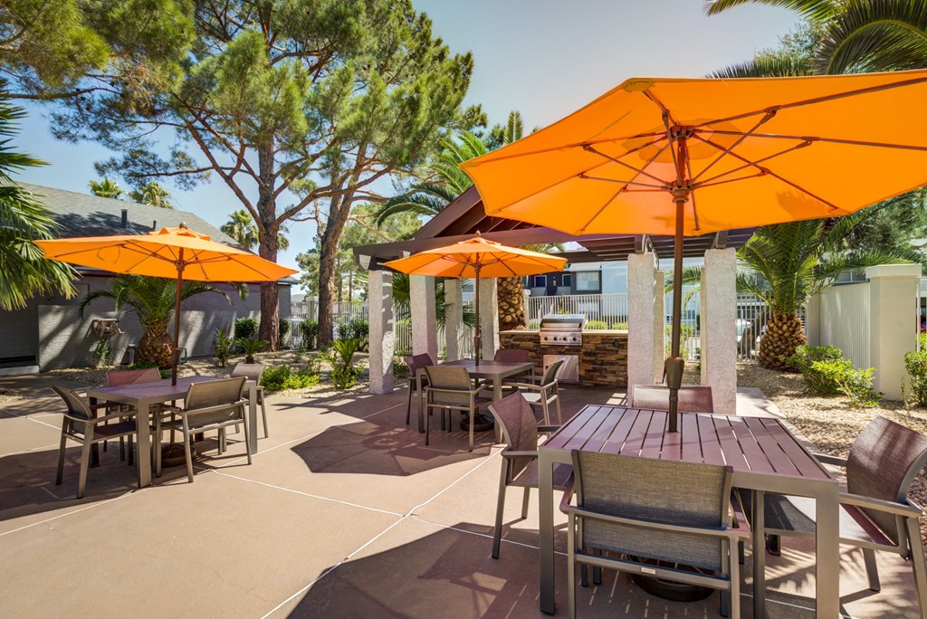 a patio with tables and chairs and umbrellas