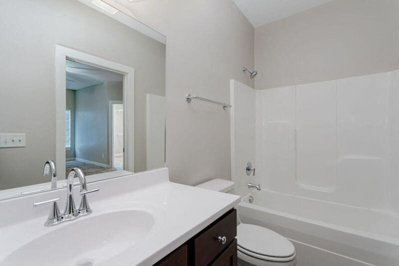 a bathroom with a sink toilet and a mirror