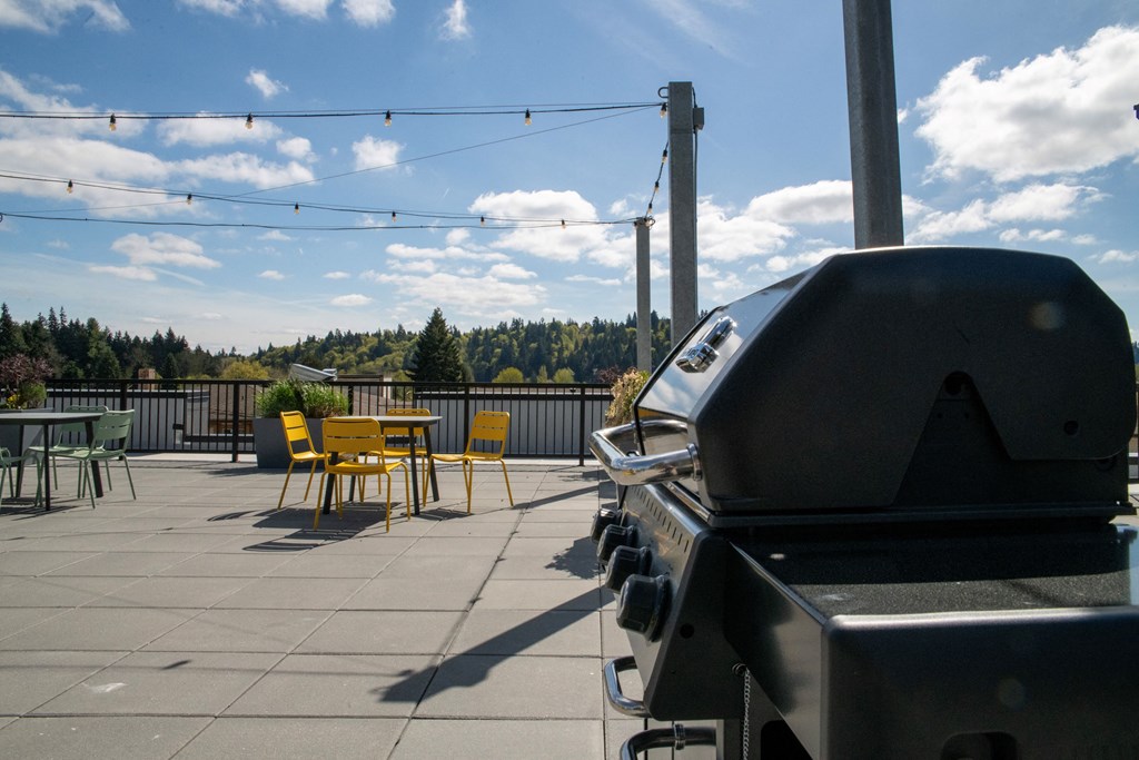 a patio with tables and chairs and a grill