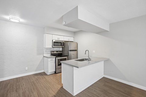 A kitchen with white cabinets and a white island.