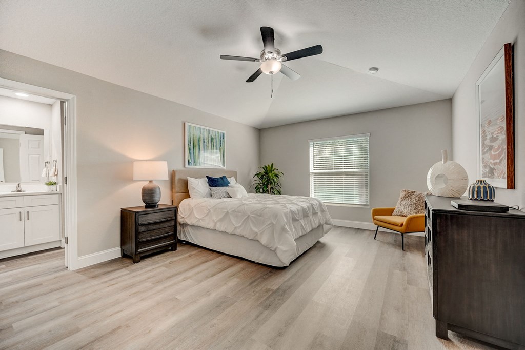 Bedroom with a bed and ceiling fan at The Groves at Lake Ella in Lady Lake, Florida, a pet-friendly rental community.