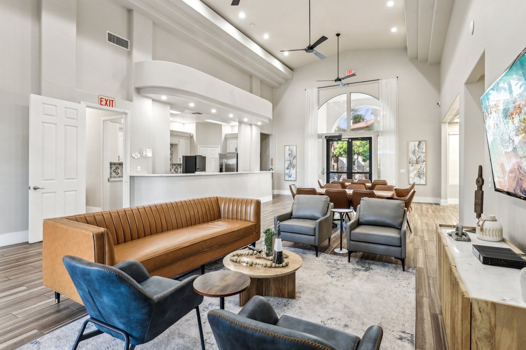 A living room with a brown couch, blue chairs, and a wooden coffee table.