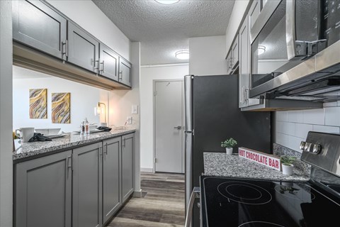 A kitchen with a black stove top oven and a sign that says "HOT CHOCOLATE BAR".