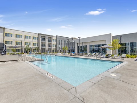 A large outdoor swimming pool in front of a building.