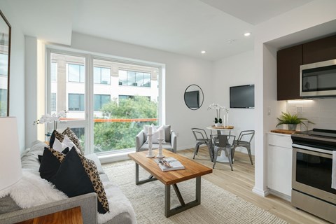 A modern living room with a grey couch and a wooden coffee table.