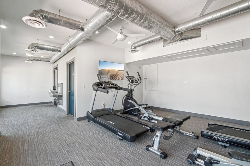 A gym with treadmills, weights, and exercise equipment.