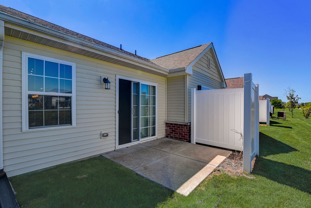 a white house with a driveway and a white fence