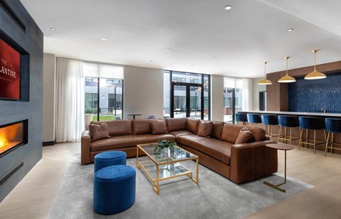 A modern living room with a brown leather sofa and a fireplace.