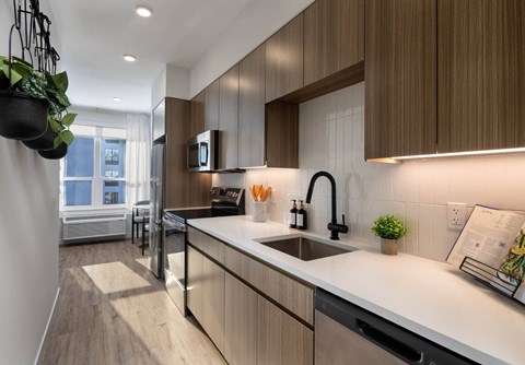 A modern kitchen with wooden cabinets and a white countertop.