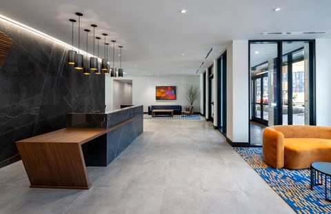 A modern office lobby with a bench, a chair, and a table.
