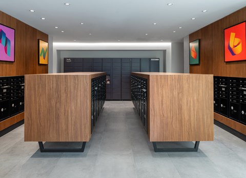 A modern office lobby with two wooden reception desks and abstract art on the walls.