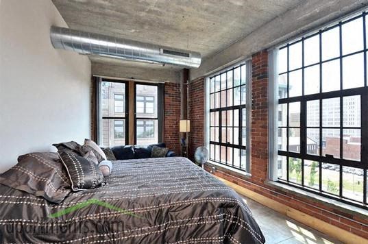 a bedroom with a bed and a large window