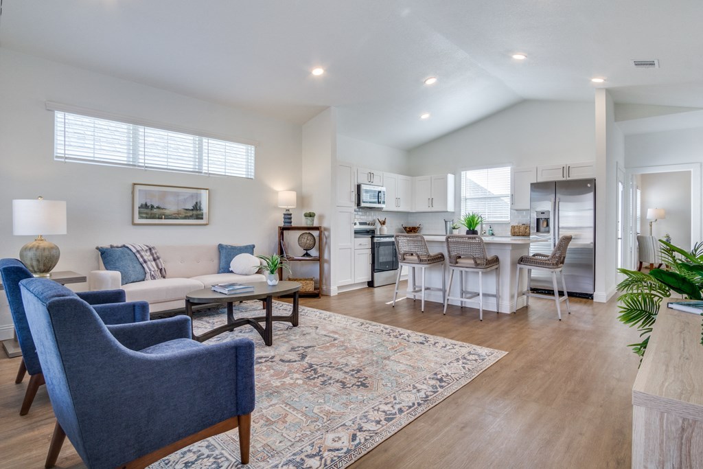 A living room with a blue chair and a white couch.