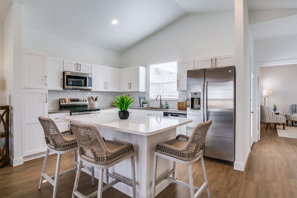 A kitchen with a white table and chairs.