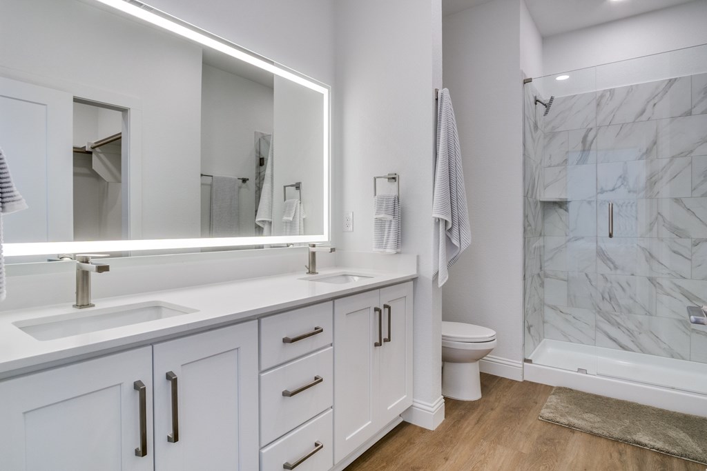 A white bathroom with a marble tile shower.