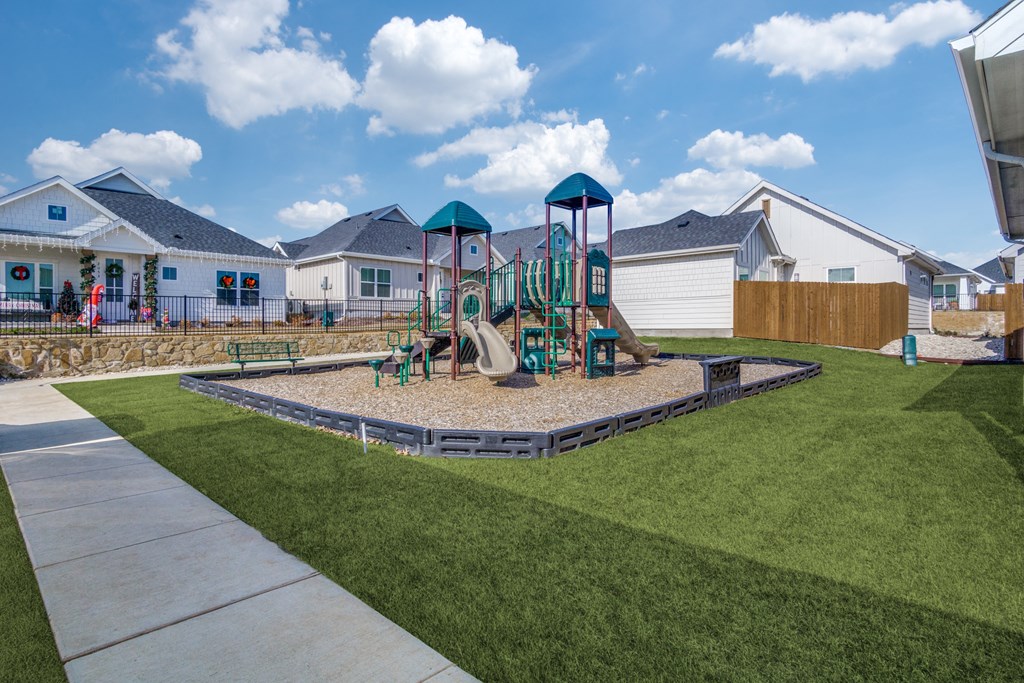 A playground with a slide and a green and blue tower.