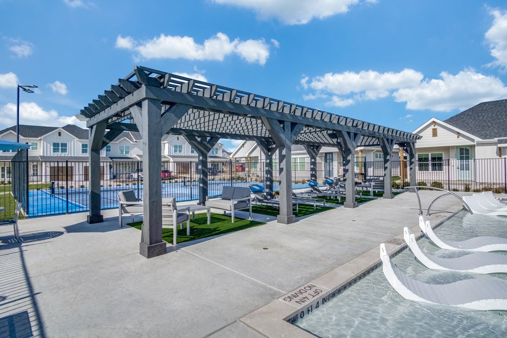A pool area with a pergola and a pool table.