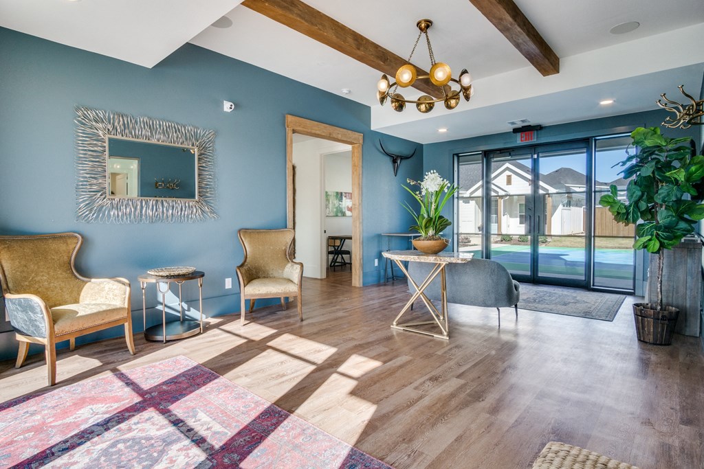 A living room with a wooden floor and a large mirror on the wall.