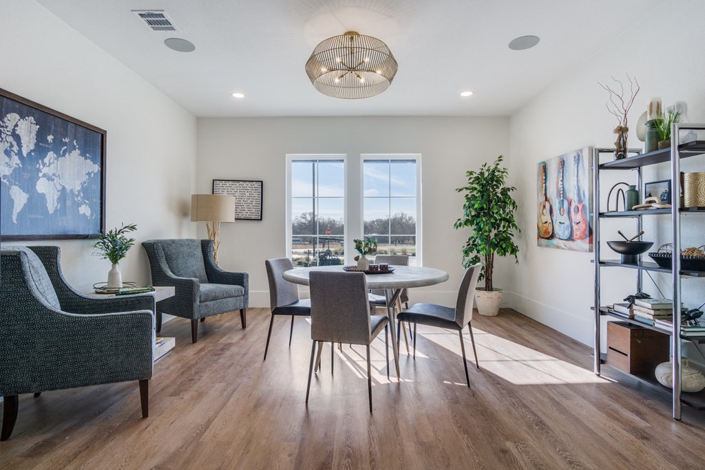 A well-lit room with a dining table and chairs.