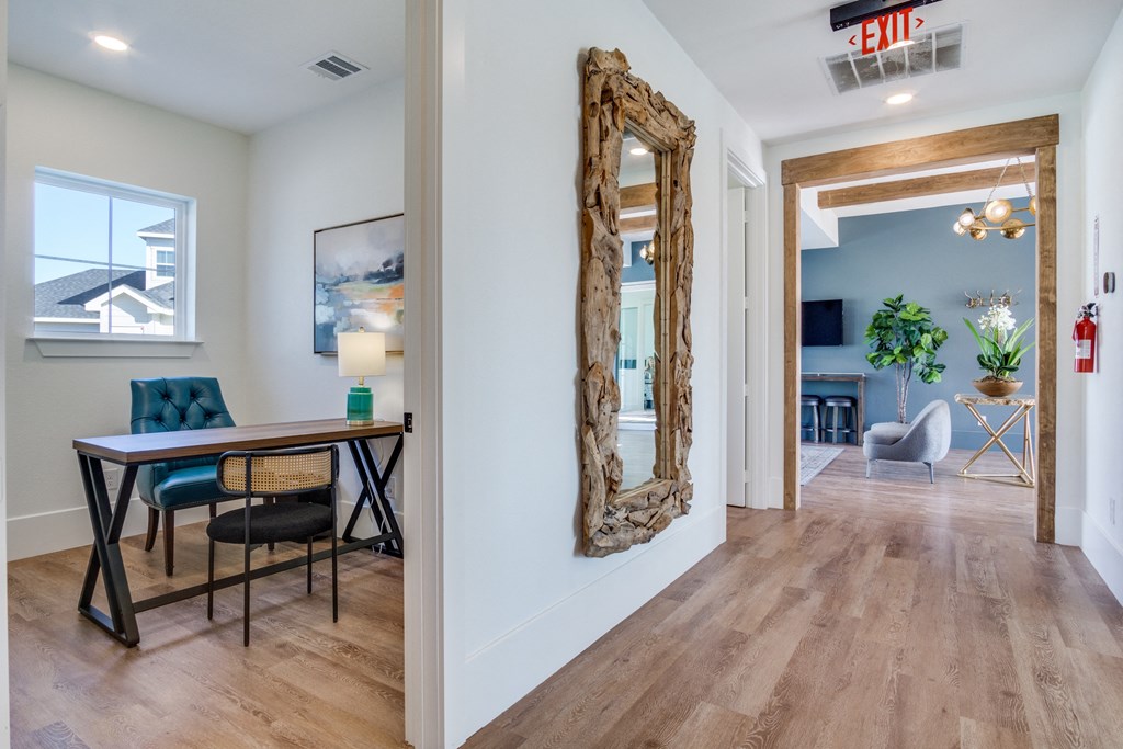 A room with a desk and a chair with a blue cushion.