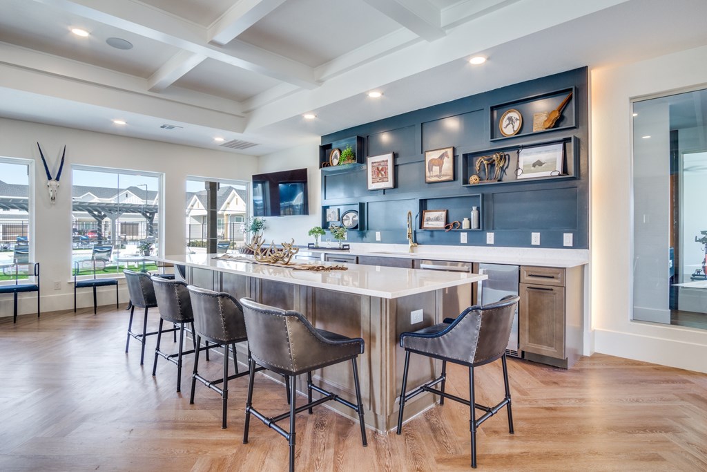 A modern kitchen with a long island and chairs.
