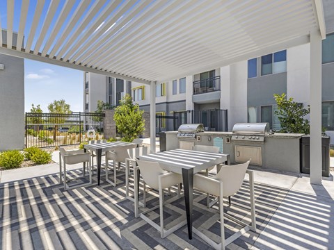 A patio with a table and chairs is covered by a white roof.