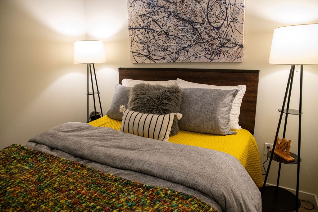 a bedroom with a bed with pillows and a painting on the wall