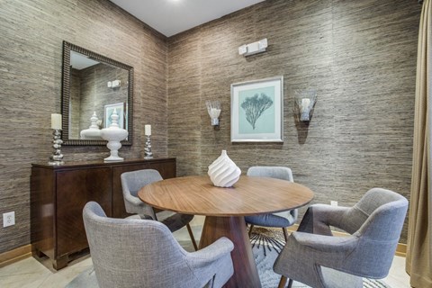 a dining room with a table and chairs and a mirror