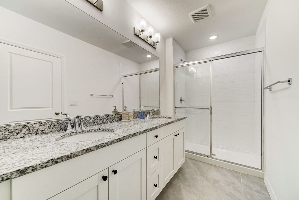 Boatman Hammock Townhomes in Lake Worth, FL photo of  a bathroom with white cabinets and a sink and a shower