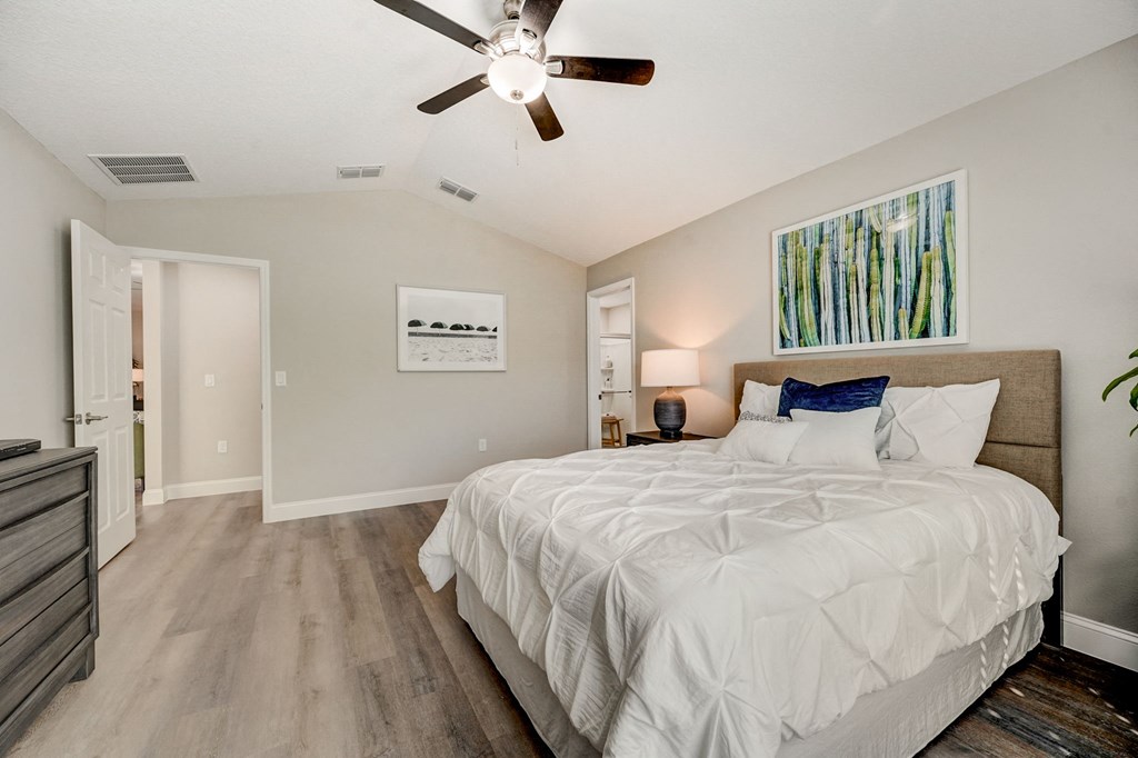 Master bedroom featuring a large bed and ceiling fan at The Groves at Lake Ella in Lady Lake, Florida, a pet-friendly rental community.