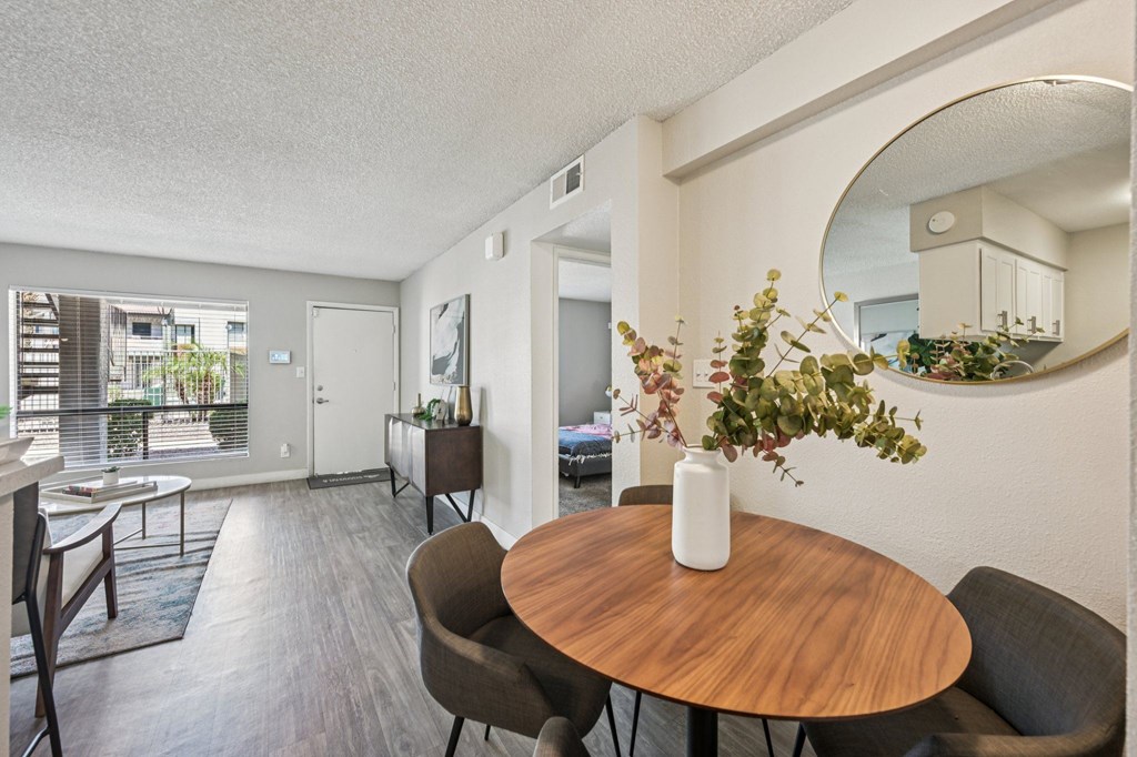 A dining room with a round wooden table and chairs.