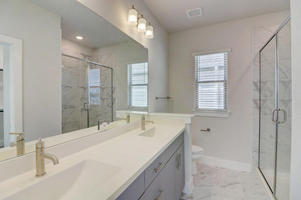 a bathroom with a sink and a shower and a mirror