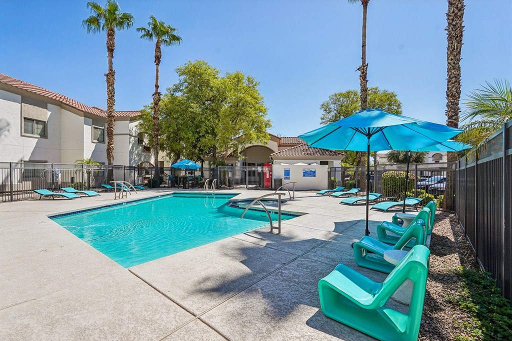 A pool surrounded by palm trees and sun loungers.